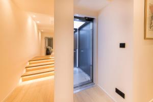un pasillo con una puerta de cristal y escaleras en Luxury 3 bedrooms townhouse in perfect location, en Bruselas