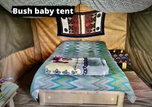 Una cama en una tienda con una almohada. en Eselbe Camp Backpackers en Nata