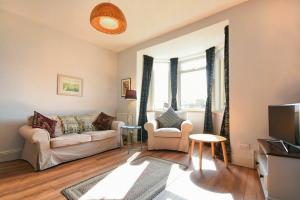 a living room with a couch and a tv at Rosedale House in Amble