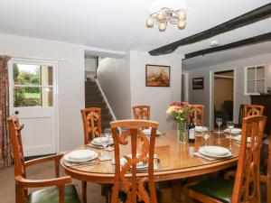 a dining room with a wooden table and chairs at Twelve Oaks Farmhouse in Newton Abbot