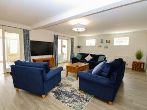 a living room with two blue couches and a television at Drifters in Great Yarmouth