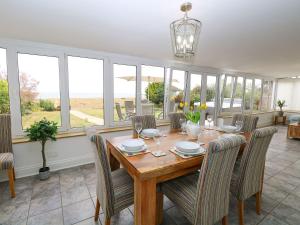 a dining room with a table and chairs and windows at Drifters in Great Yarmouth