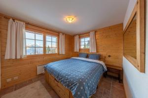 ein Schlafzimmer mit einem Bett in einem Zimmer mit Holzwänden in der Unterkunft Chalet Ciel de Lit in Nendaz