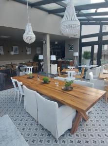a dining room with a wooden table and white chairs at DESIGN hotel VERBENICUM in Vrbnik