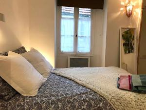 a bedroom with a bed with white pillows and a window at L'appartement Vaugirard in Paris