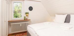 a white bedroom with a bed and a window at BlackNCozy - Großzügiges Designappartement mit Boxspringbetten und Heimkino in Feldberg
