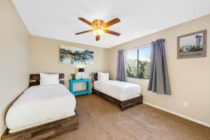 a bedroom with two beds and a ceiling fan at Blue Canyon Paradise in Twentynine Palms