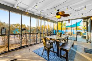 a dining room with a table and chairs and large windows at Blue Canyon Paradise in Twentynine Palms