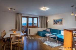 a living room with a blue couch and a table at Apartmány Villa Severka in Vysoke Tatry - Novy Smokovec