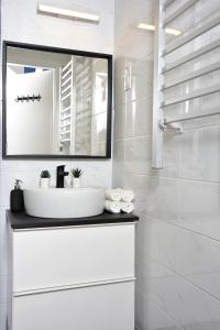 uma casa de banho branca com um lavatório e um espelho em Casa Bacsó em Budapeste