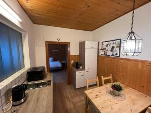 a kitchen with a table and a room with a bed at City-apart Kitzbühel in Kitzbühel