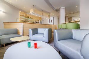 a waiting room with two chairs and a table at Hôtel Ariane in Lourdes