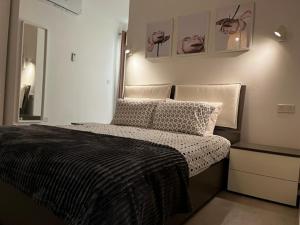 um quarto com uma cama com um edredão preto e branco em Sliema, Apt7, Stylish 2 Bedroom Apartment with Parking em Sliema