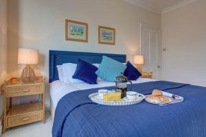 Una cama azul con una bandeja de comida. en Fabulous Seaside Retreat, en Hunstanton