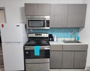 uma cozinha com um frigorífico, um fogão e um micro-ondas em Casa Loma Panama City Beach - Beachfront em Panama City Beach
