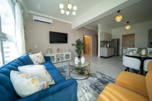 a living room with a blue couch and a kitchen at Sdq, Gym, Pool, 1br 2B, Downtown F7 in Santo Domingo