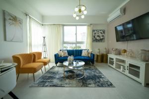 a living room with a blue couch and a table at Sdq, Gym, Pool, 1br 2B, Downtown F7 in Santo Domingo