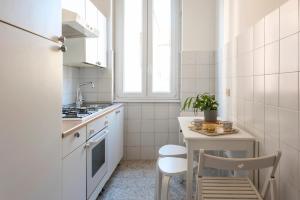 uma pequena cozinha branca com mesa e cadeiras em Urbana Rooftop em Roma