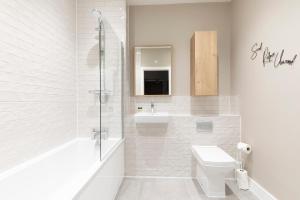 uma casa de banho branca com um WC e um lavatório em Elliot Oliver - Stylish Loft Style Two Bedroom Apartment With Parking em Gloucester