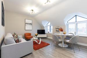 uma sala de estar com um sofá e uma mesa em Elliot Oliver - Stylish Loft Style Two Bedroom Apartment With Parking em Gloucester