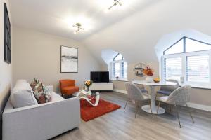 ein Wohnzimmer mit Sofa und Tisch in der Unterkunft Elliot Oliver - Stylish Loft Style Two Bedroom Apartment With Parking in Gloucester