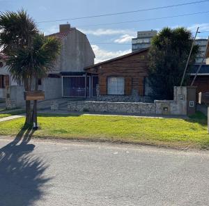 una casa con una palmera frente a una calle en LOS ABUELOS Casa a 50 metros del mar en Mar del Plata