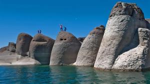 Tres personas de pie sobre rocas cerca del agua en Céntrico Departamento Tangerine San Rafael, en San Rafael