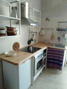 a kitchen with white cabinets and a wooden counter top at Marsò _ Piccolo rifugio cittadino in Turin