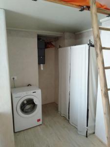 a laundry room with a washing machine and a refrigerator at Marsò _ Piccolo rifugio cittadino in Turin