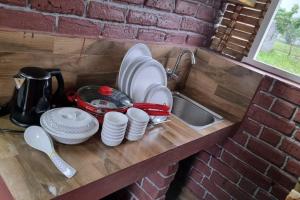 a kitchen counter with plates and dishes on it at Woodside Haven in Auroville