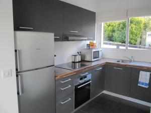 a kitchen with a refrigerator and a microwave at La Regina in Trouville-sur-Mer