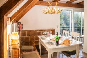 a dining room with a white table and a chandelier at BlackNCozy - Großzügiges Designappartement mit Boxspringbetten und Heimkino in Feldberg