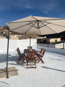 a table and chairs under an umbrella on a roof at Villa Alegria in Gérgal