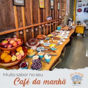 a long table with a buffet of food at Pousada Rota da Kombi in Bom Jardim da Serra