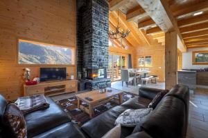 a living room with a leather couch and a fireplace at Chalet Amerhone - Luxury chalet With Jacuzzi in Riddes