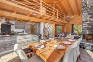 uma sala de jantar com uma longa mesa de madeira e cadeiras em Chalet Amerhone - Luxury chalet With Jacuzzi em Riddes