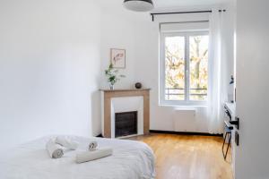 a white bedroom with a bed and a fireplace at Appartement Chantenay 4 pers in Nantes