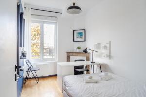 a white bedroom with a bed and a desk at Appartement Chantenay 4 pers in Nantes