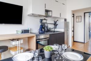 a kitchen with a table with wine glasses on it at Appartement Chantenay 4 pers in Nantes