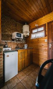 a kitchen with a white refrigerator and a microwave at Cabañas del Golf in Sierra de la Ventana