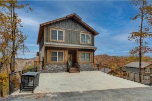 a house with a large patio in front of it at Blue Moon Ridge: Brand NEW Cabin! 5 bedrooms, pool/hot tub, theatre in Pigeon Forge