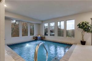 a swimming pool in a house with windows at Blue Moon Ridge: Brand NEW Cabin! 5 bedrooms, pool/hot tub, theatre in Pigeon Forge
