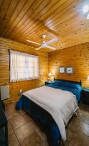 a bedroom with a large bed in a wooden cabin at Cabañas del Golf in Sierra de la Ventana
