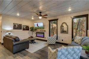 a living room with a couch and a tv at Blue Moon Ridge: Brand NEW Cabin! 5 bedrooms, pool/hot tub, theatre in Pigeon Forge