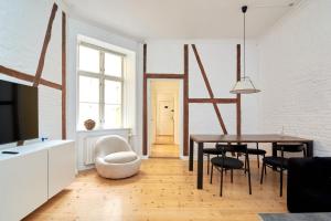 sala de estar con mesa, sillas y TV en Scandinavian Style 3BR in Copenhagen City Centre, en Copenhague