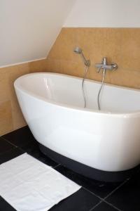 eine weiße Badewanne mit einem Wasserhahn im Bad in der Unterkunft Wohnen am Dehnthof Haus 1 in Kappeln