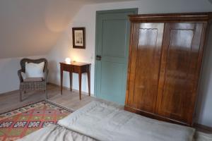 1 dormitorio con 1 cama, armario de madera y mesa en Wohnen am Dehnthof Haus 1, en Kappeln