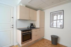 une cuisine avec une cuisinière et des placards ainsi qu'une fenêtre dans l'établissement Spacious 3B w Double Beds Copenhagen City Centre, à Copenhague