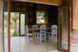 a dining room with a table and white chairs at Art House at Chiangdao - Lake House in Chiang Dao +46 photos