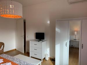 sypialnia z łóżkiem i telewizorem na komodzie w obiekcie MILANO 71 HOME w Mediolanie